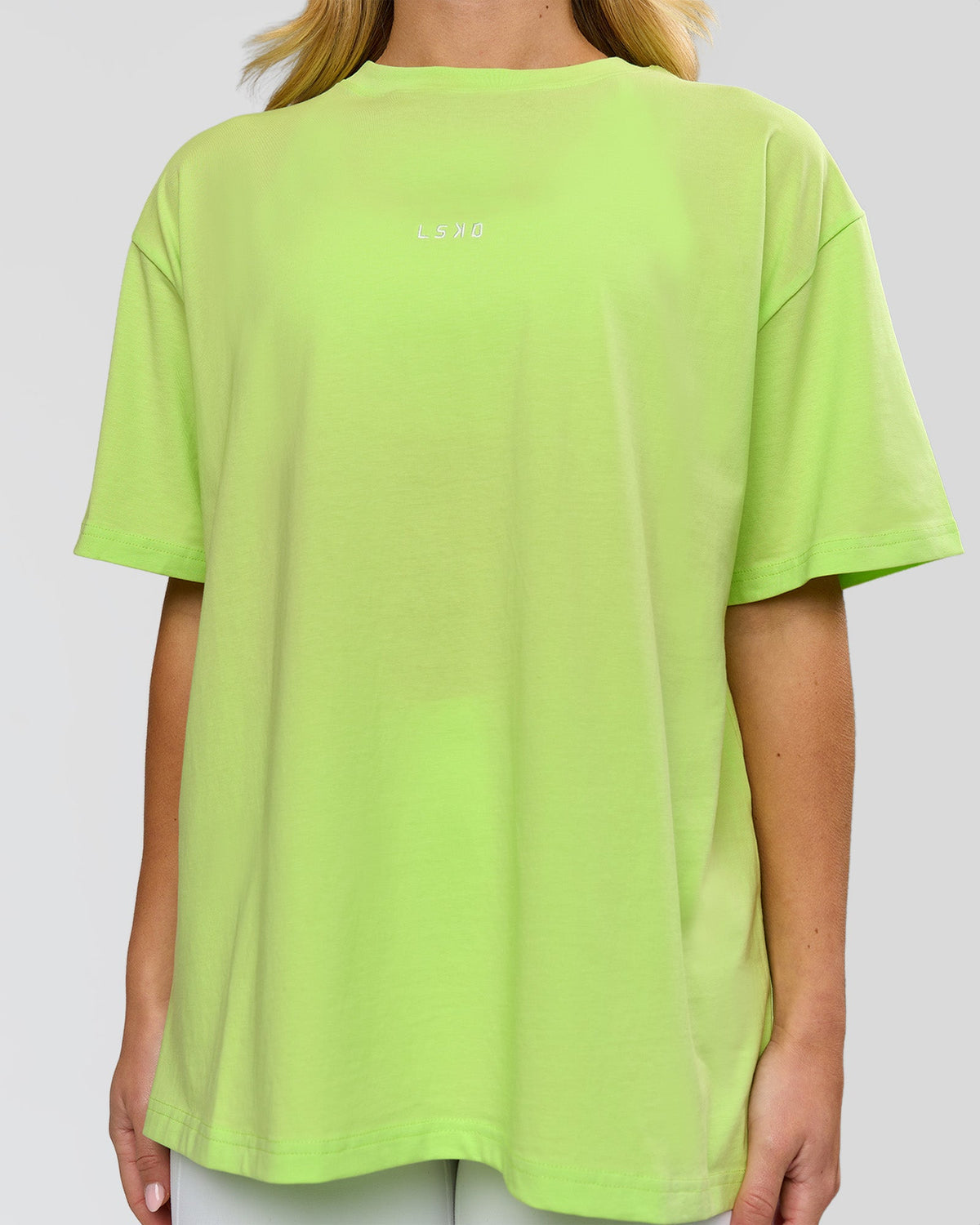Woman wearing Go-To FLXCotton Oversized Tee - Lime Glo-White | Model:Issy | Size:XS