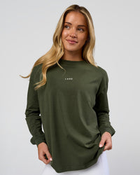 Woman wearing Go-To Long Sleeve FLXCotton Oversized Tee - Pure Olive-White | Model:Issy | Size:XS | Thumbnail Index: 0