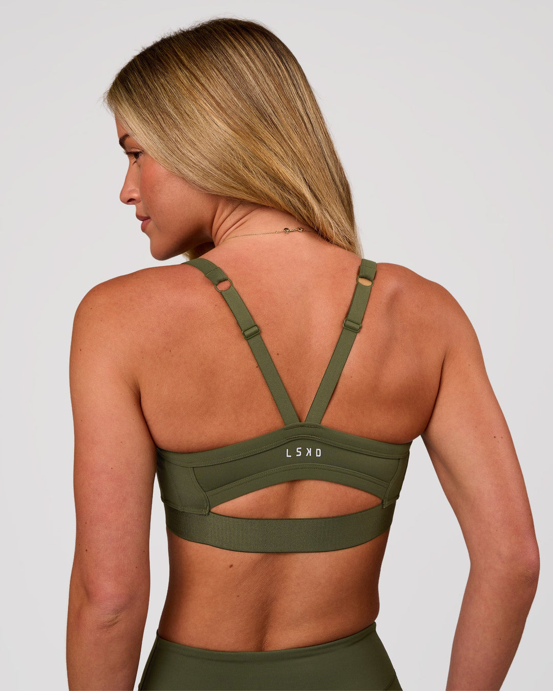 Woman wearing Momentum Corset Sports Bra - Pure Olive | Model:Issy | Size:XS - view 2