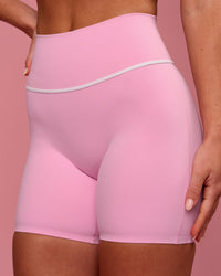 Woman wearing Pinnacle High-Rise 6" Short - Pink Rose-White | Model:Issy | Size:XS | Thumbnail Index: 1