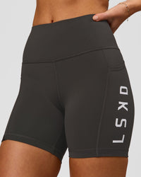 Woman wearing Rep Ultra High-Rise 4" Short Pockets - Onyx-White | Model:Issy | Size:XS | Thumbnail Index: 0