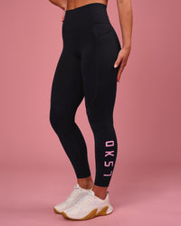 Woman wearing Rep Ultra High-Rise 7/8 Legging Pockets - Black-Pink Rose | Model:Issy | Size:XS | Thumbnail Index: 0