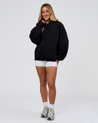 Woman wearing Tonal Legacy Boxy Hoodie - Black-Black | Model:Issy | Size:XS | Thumbnail Index: 14