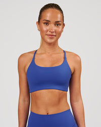 Woman wearing Twist Sports Bra - Power Cobalt | Model:Issy | Size:XS | Thumbnail Index: 0