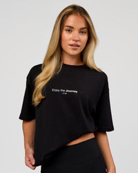 Woman wearing VS1 Enjoy The Journey FLXCotton Oversize Tee - Black | Model:Issy | Size:XS | Thumbnail Index: 2