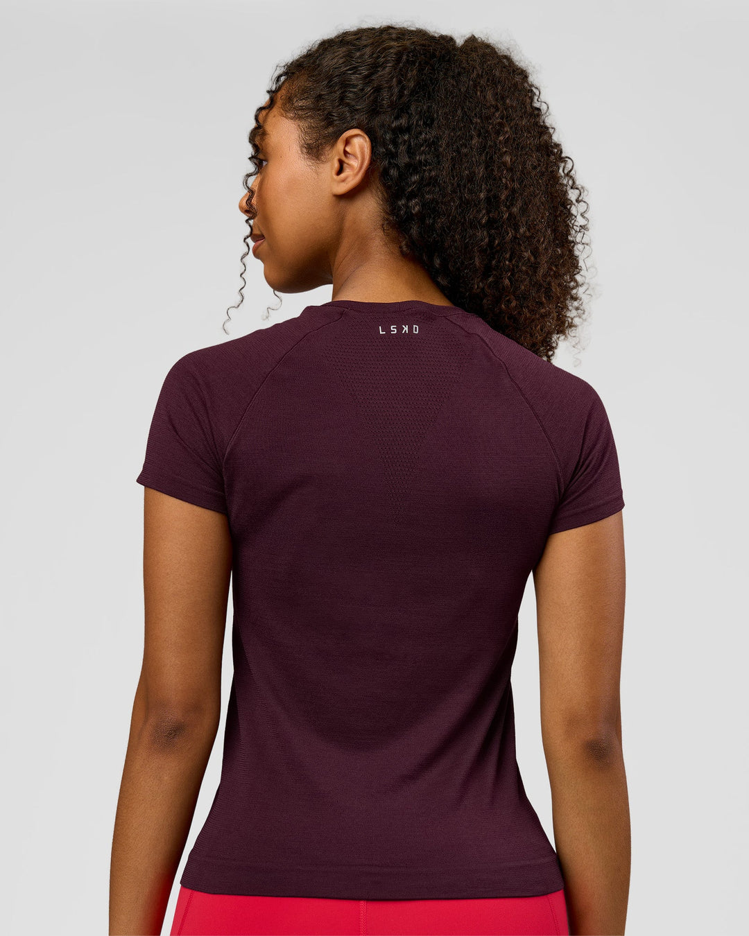 Woman wearing AeroFLX+ Seamless Tee - Cherry Lacquer/Cherry Lacquer | Model:Jordan | Size:XS - view 2