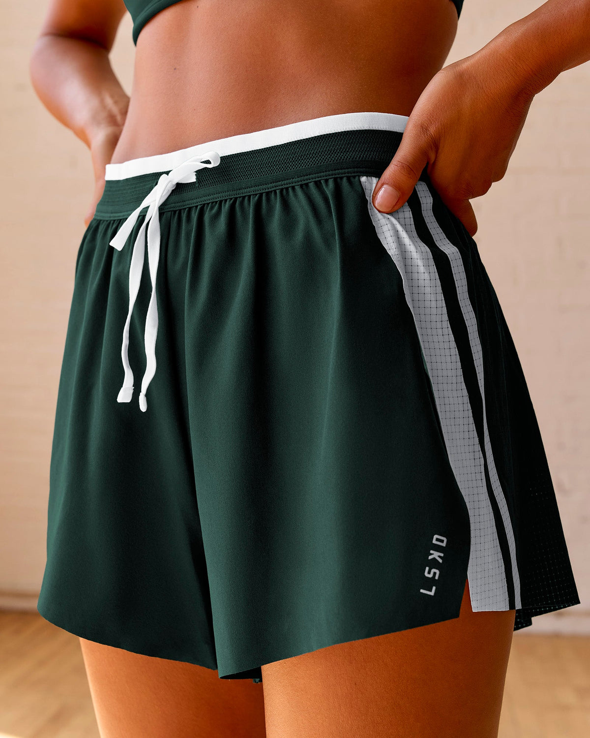 Woman wearing Trackline Accelerate 3" High-Rise Running Short - Midnight Green-White | Model:Meg | Size:XS