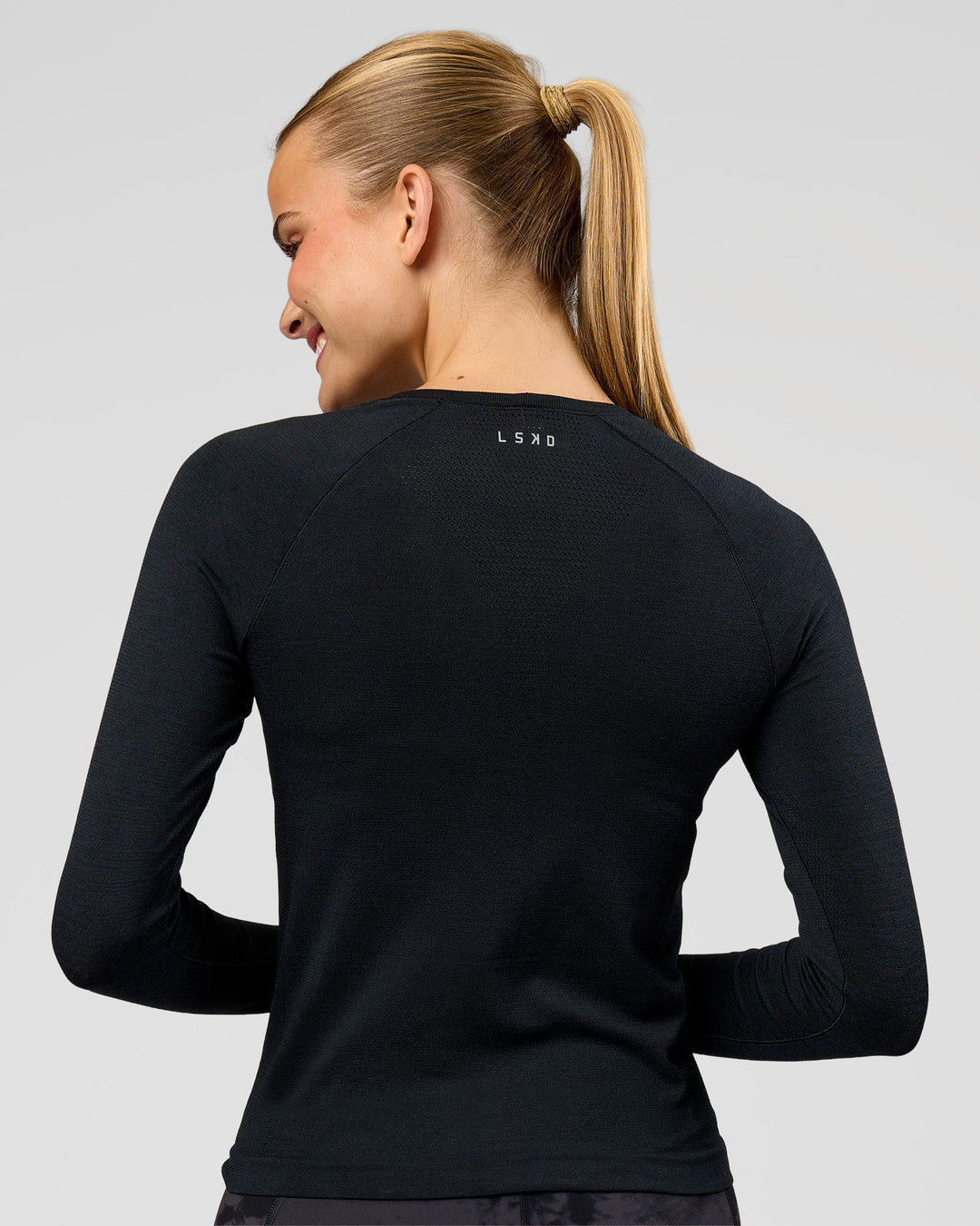Woman wearing AeroFLX+ Seamless Long Sleeve Tee - Black Marl | Model:Taneisha | Size:XS - view 4