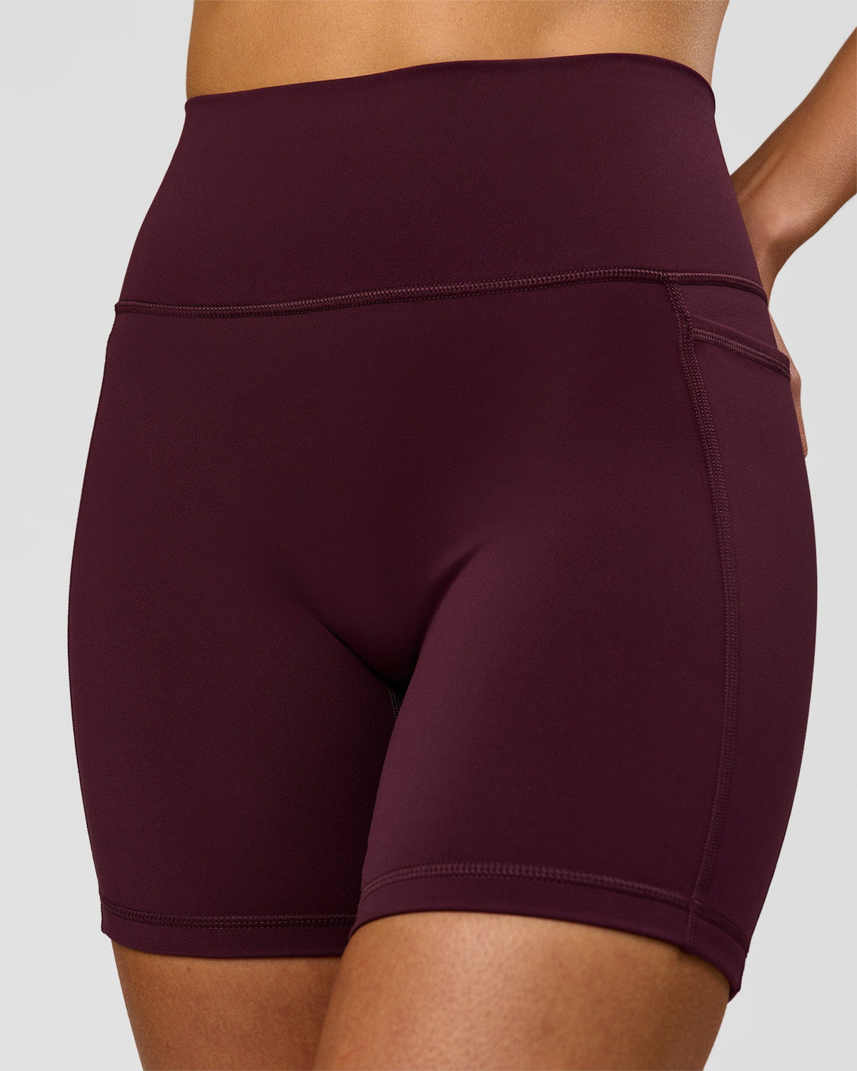 Woman wearing Fusion V-Contour Ultra High-Rise 6" Short Pockets - Cherry Lacquer | Model:Taneisha | Size:XS