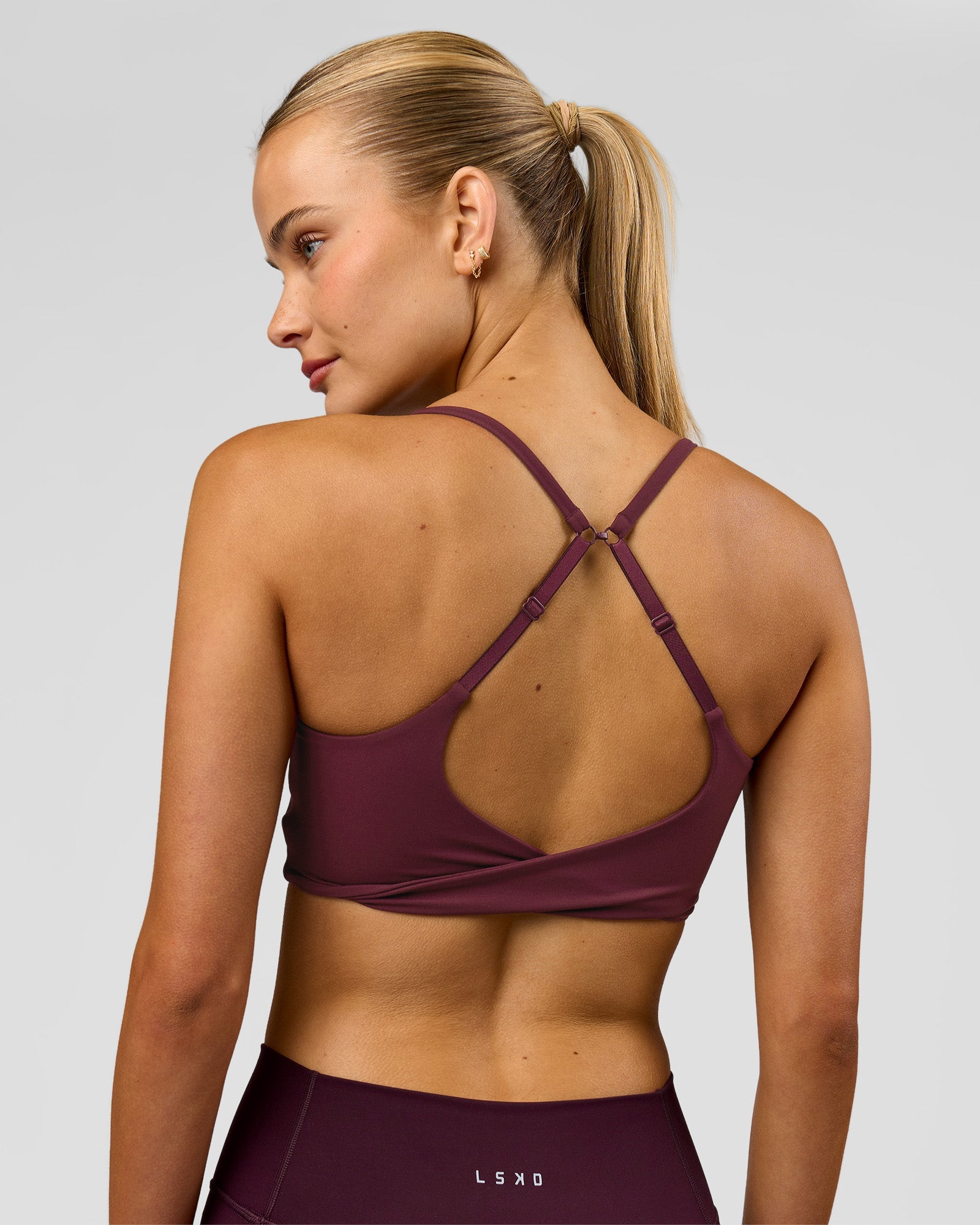 Woman wearing Twist Sports Bra - Cherry Lacquer | Model:Taneisha | Size:XS