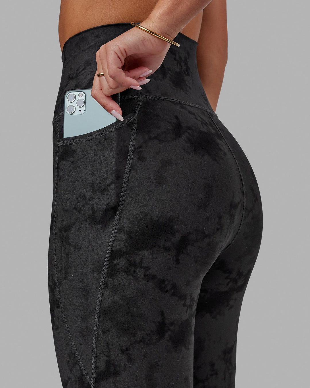 Woman wearing Fusion Ultra High-Rise 7/8 Legging Pockets - Black Tie-Dye | Model:Milly | Size:S