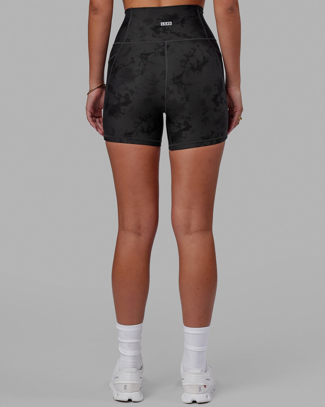 Woman wearing Fusion Ultra High-Rise 4" Short Pockets - Black Tie-Dye | Model:Milly | Size:S