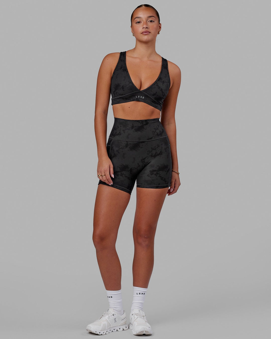 Woman wearing Fusion Ultra High-Rise 4" Short Pockets - Black Tie-Dye | Model:Milly | Size:S