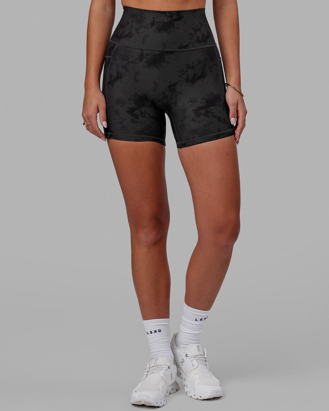 Woman wearing Fusion Ultra High-Rise 4" Short Pockets - Black Tie-Dye | Model:Milly | Size:S