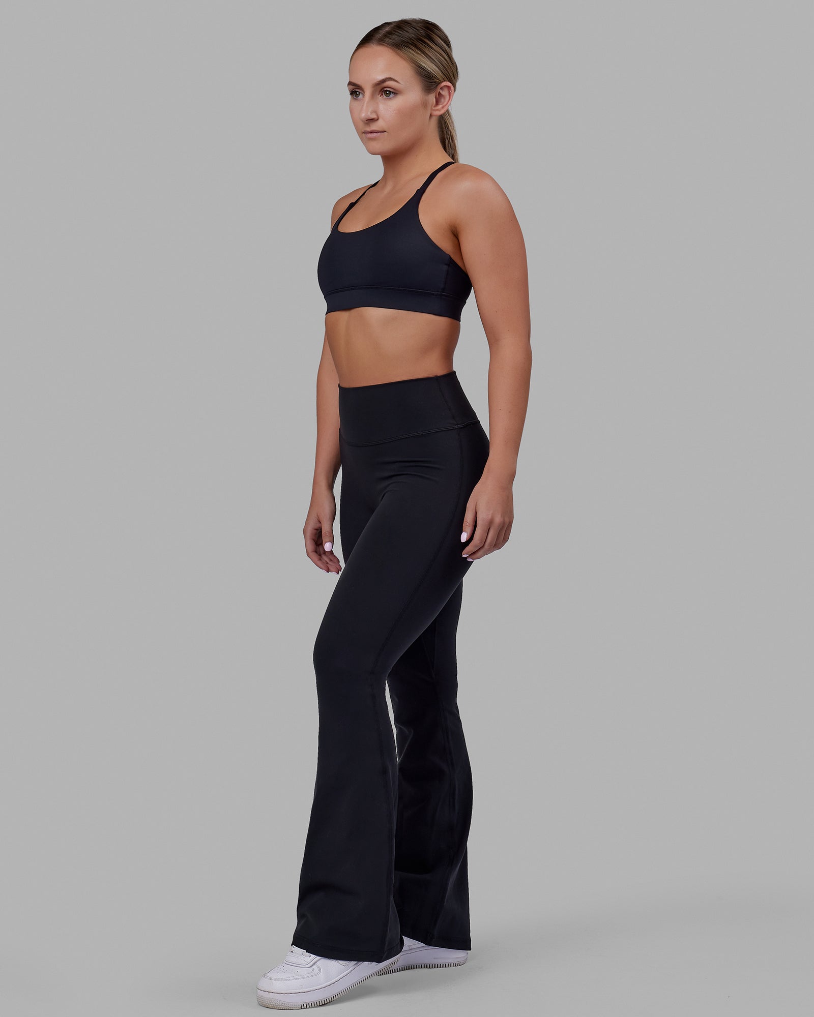 Woman wearing Fusion Ultra High-Rise Flared Petite Legging - Black| Model:Gracie | Size:S