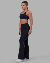 Woman wearing Fusion Ultra High-Rise Flared Petite Legging - Black| Model:Gracie | Size:S