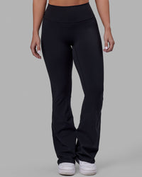 Woman wearing Fusion Ultra High-Rise Flared Petite Legging - Black| Model:Gracie | Size:S