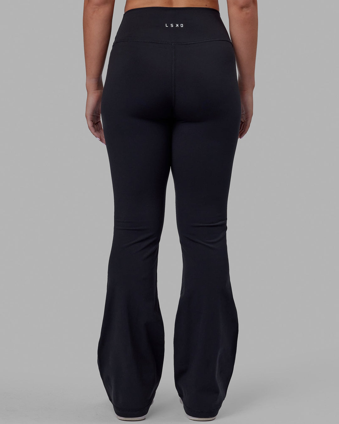 Woman wearing Fusion Ultra High-Rise Flared Petite Legging - Black| Model:Gracie | Size:S