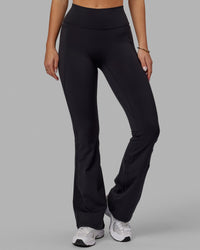 Woman wearing Fusion Ultra High-Rise Flared Legging Pockets - Black | Model:Milly | Size:S