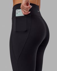 Woman wearing Fusion Ultra High-Rise Flared Legging Pockets - Black | Model:Milly | Size:S