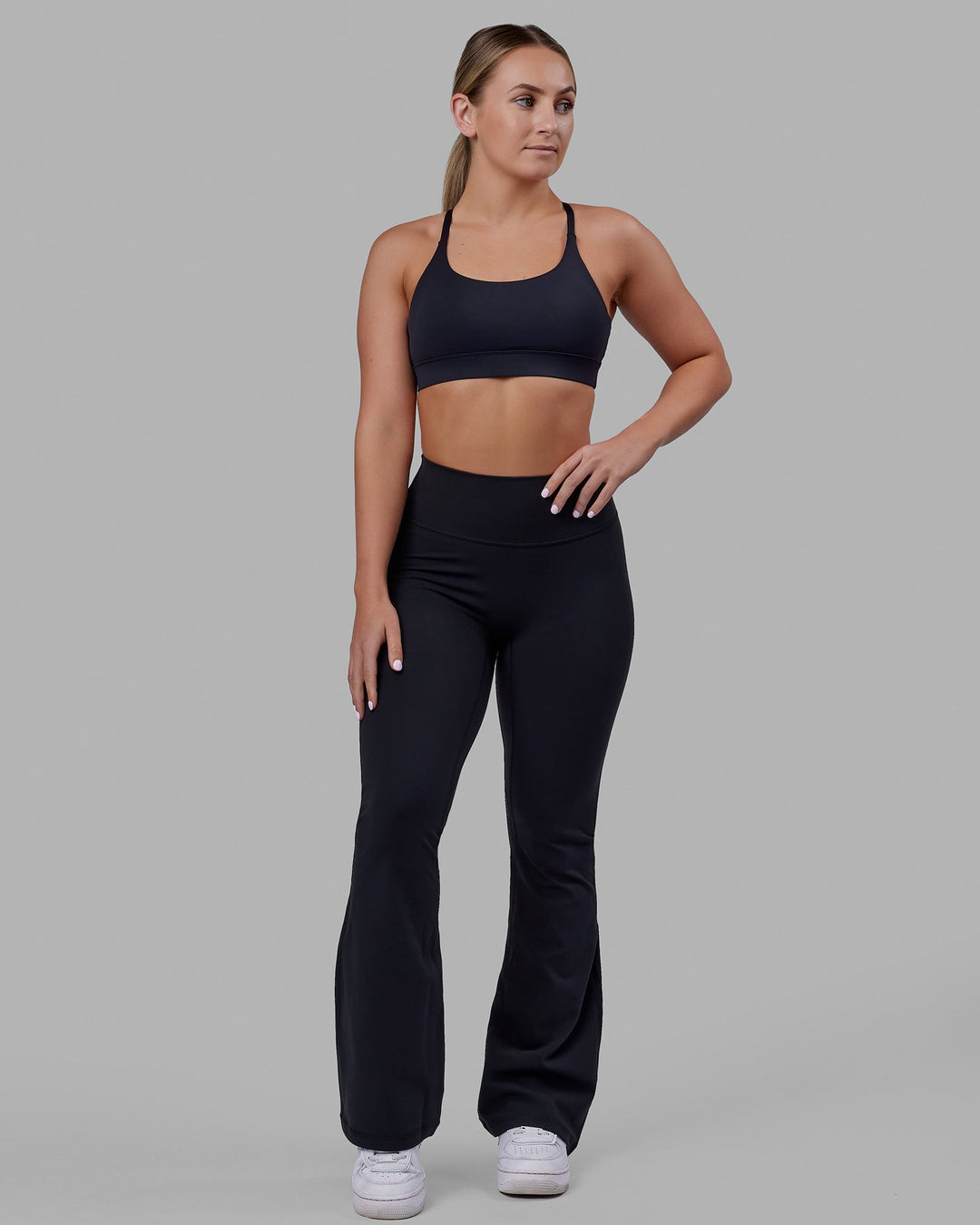 Woman wearing Fusion Ultra High-Rise Flared Petite Legging - Black| Model:Gracie | Size:S